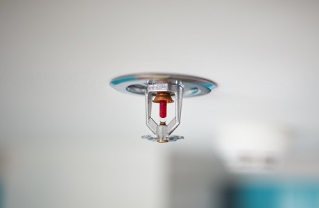 Close up of water sprinkler on a white ceiling representing Efficacy insurance